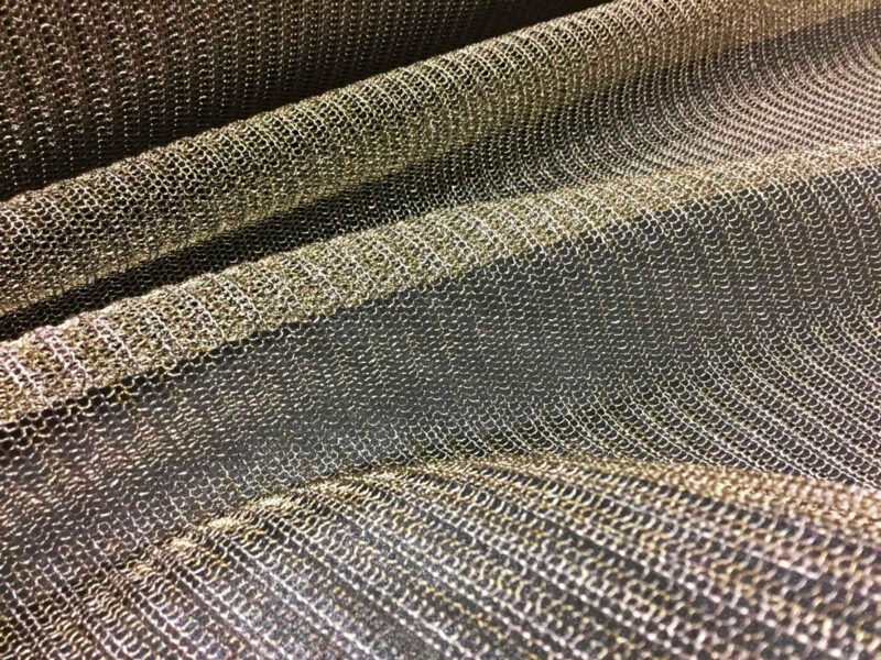 Tessuto a righe tessuto in colori terrosi, texture di stoffa cucita a pannelli sovrapposti, primo piano con cuciture visibili.
