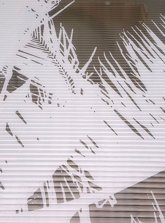 Dettagli astratti con linee orizzontali e ombre sfumate, colori beige e grigio su sfondo chiaro su un tessuto metalizzato.